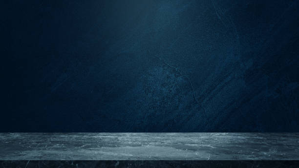 istock empty marble table at foreground and cement stone at background with blue light from above for product displayed in rustic mood. blue backdrop. abstract background for product stand for advertising. 1616883237