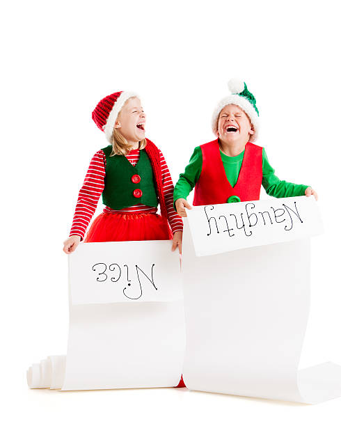 Two Christmas Elves Hold Santas List Naughty and Nice Two young elves hold Santa's list of the naughty and nice girls and boys. child laughing hysterically stock pictures, royalty-free photos & images