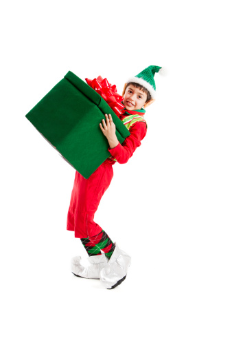 A Hispanic elf, one of Santa's helpers, struggles with a big, heavy Christmas present.