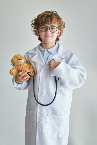 istock Smiling boy doctor with stethoscope and soft bear 1616910398