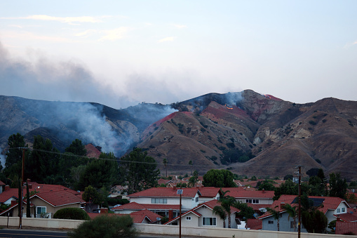 A snapshot of a wildfire burning in the hills of an Orange County suburb in California.