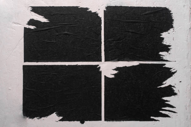 istock Old billboard with sheets of black torn paper. 1616922121