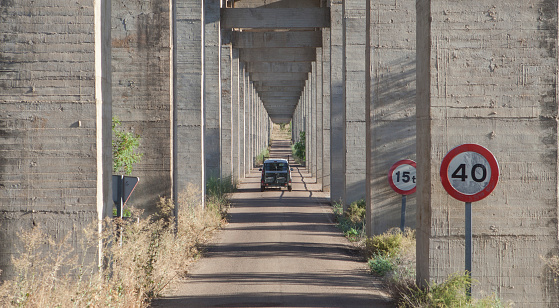 Vehicle crossing the road under Acedera Aqueduct, Vegas Altas del Guadiana, Badajoz, Extremadura, Spain