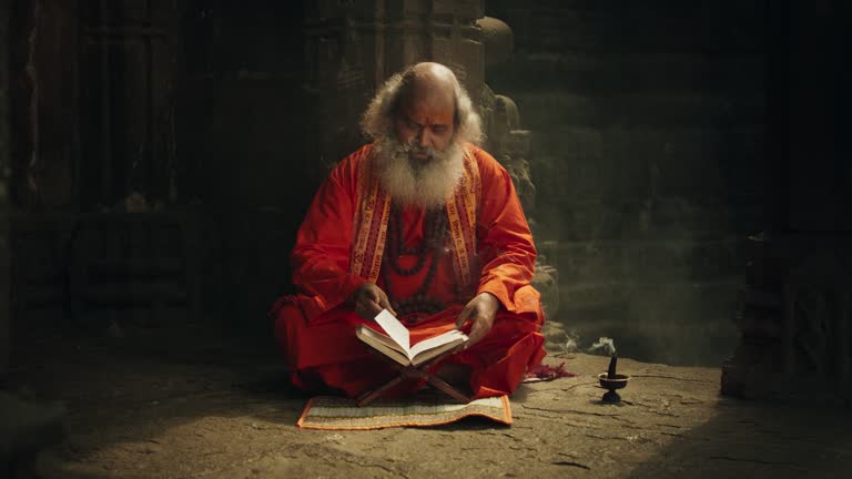 Slow Motion Portrait of Old Indian Monk Reading a Book in an Ancient Temple. Senior Guru Getting Wisdom from Sacred Texts, Humble Male Devoted to Hinduism, Gaining Knowledge and Spiritual Connection