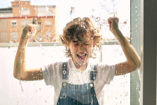 istock Positive boy knocking on foamy window 1616946178
