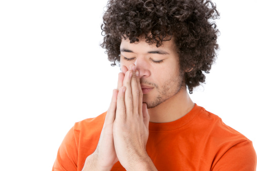 A head and shoulders image of a praying or  meditating mixed race (Caucasian, Black) young adult man.   For similar images, please click on the lightboxes below: