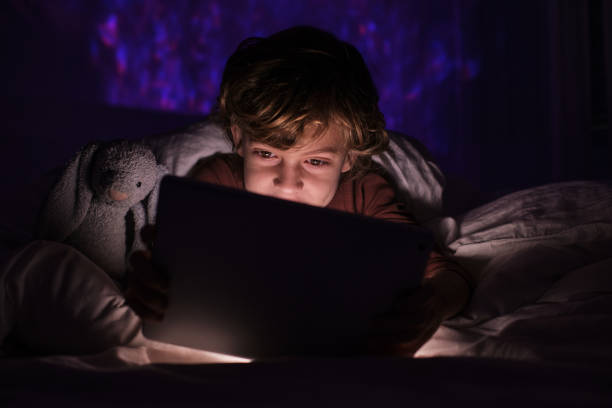 istock Child watching video on tablet in darkness 1616961785