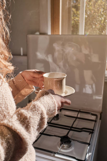istock Unrecognizable woman with cup of coffee in kitchen 1616970500