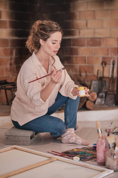 istock Young woman painting in creative workspace 1616973692