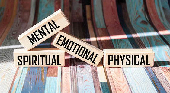 Mental Spiritual Emotional Physical written on wooden blocks and vintage background