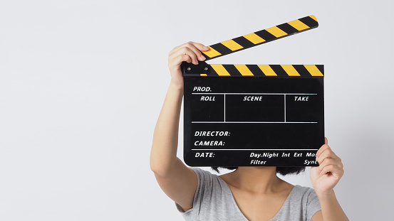 Girl or woman hand's holding black clapper board or movie slate use in video production ,film, cinema industry on white background.
