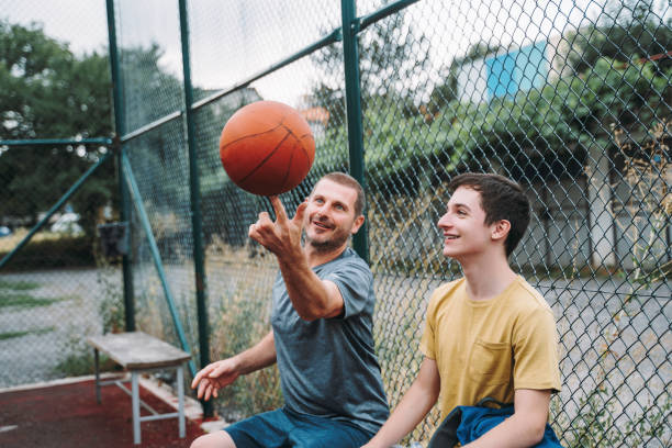 istock Morning Training. Father And Son Playing Basketball. Conversation between father and a son 1616985575