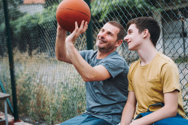 istock Morning Training. Father And Son Playing Basketball. Conversation between father and a son 1616985589