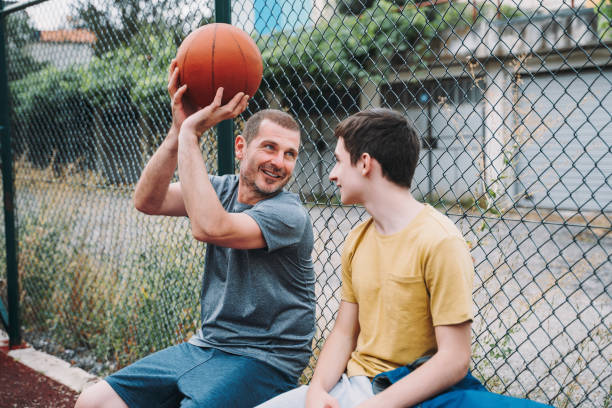 istock Morning Training. Father And Son Playing Basketball. Conversation between father and a son 1616985598
