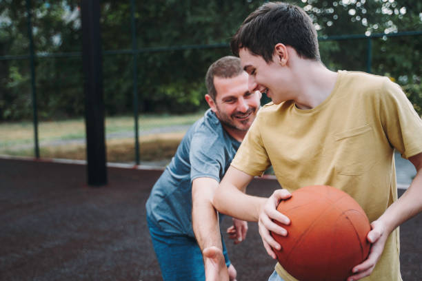 istock Morning Training. Father And Son Playing Basketball. Conversation between father and a son 1616985607