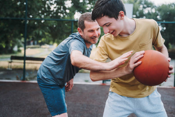 Morning Training. Father And Son Playing Basketball. Conversation between father and a son stock photo