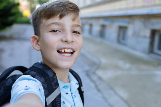 istock Back to school. Happy boy with backpack is taking selfie in school yard. He is going to school after summer break. Schoolboy is ready for new schoolyear. 1617011586