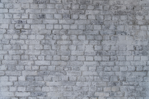 Abstract textured interior background. Front view of gray weathered brick wall. Copy space for your text or decoration.