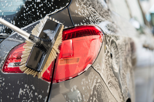 Washing a car with scrub brush.