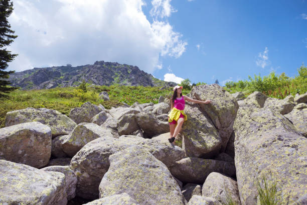 Woman standing high in the  summer mountain with stunning  view