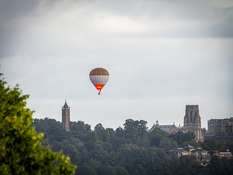 A hot air balloon flying between Wills Memorial and Cabot Tower in Bristol, UK