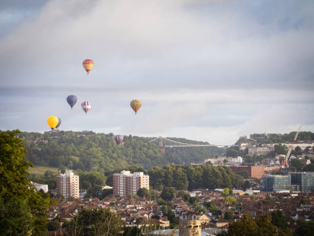 istock Hot air balloons flying over a bridge 1617043038