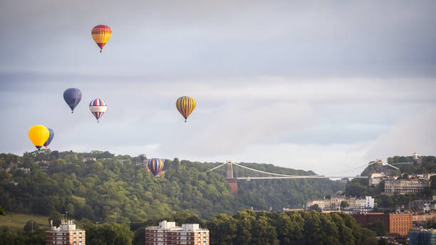 istock Hot air balloons flying over a bridge 1617043042