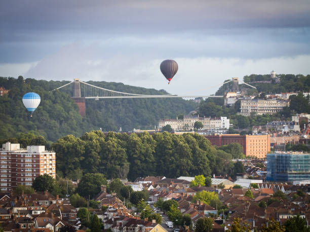 istock Hot air balloons flying over a bridge 1617043053