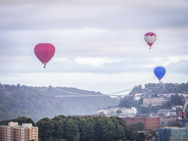 istock Hot air balloons flying over a bridge 1617043058