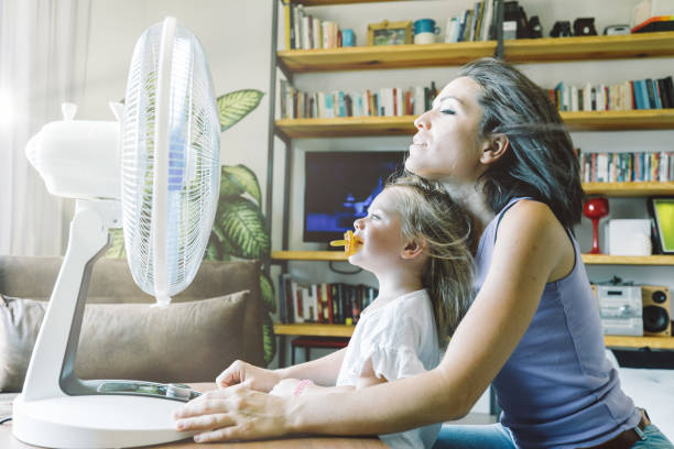istock Fan's coolness; mother, daughter's joyful play 1617044121