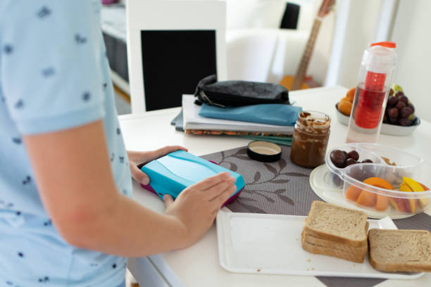 back to school. boy is preparing lunch, snack for school. healthy eating, fruit, nut and  sandwiches. - child human hand sandwich lunch box imagens e fotografias de stock