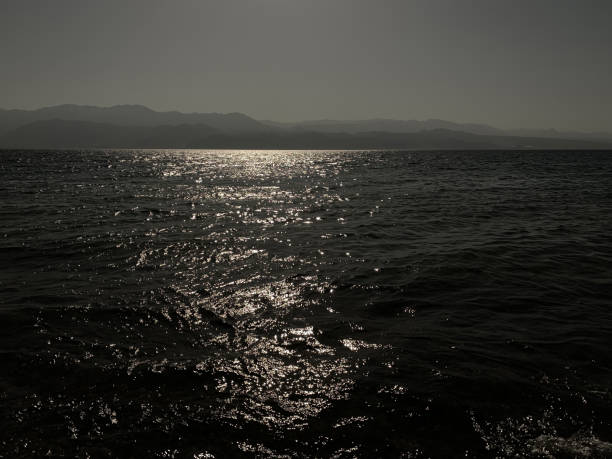 Sea Sunset Sunlight Wave Pattern Rippled Seascape Mountain Sky Horizon Reflection Lake River Abstract Background Autumn Summer Black White Dark Silver Ombre Water Texture Underexposed Photo for presentation, flyer, card, poster, brochure, banner