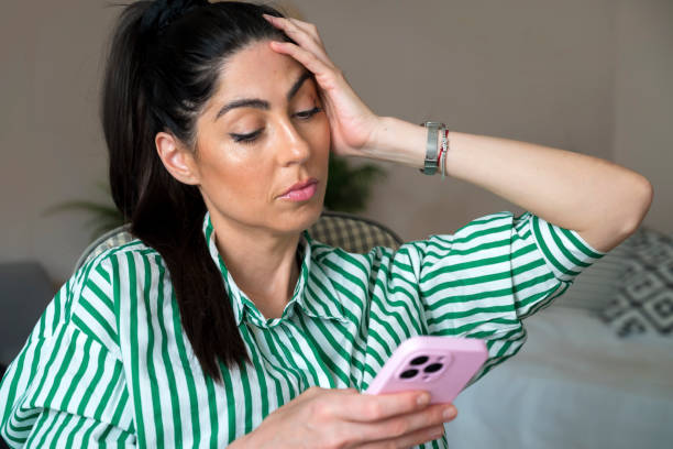istock Sad Woman  using her phone at home 1617098745