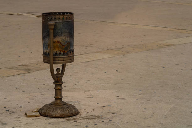 A rusty metal trash can, in which a fire once occurred and burned out, was heavily covered with soot and soot. Self-ignition, favorable conditions, human factor, spread of flames