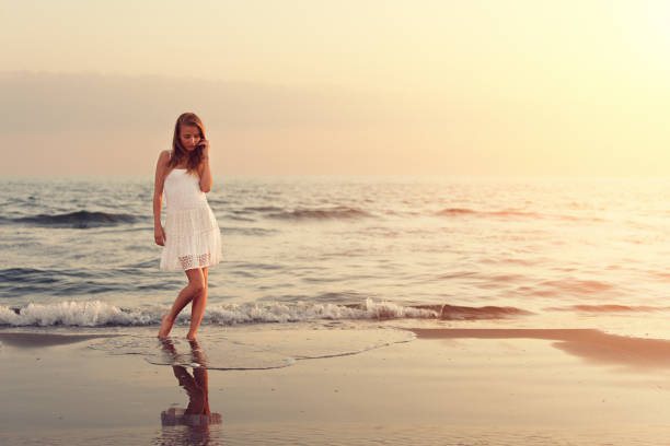 istock girl walking on the beach at sunset 161712495