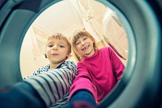 istock Brother and sister unloading a washing machine 161712617