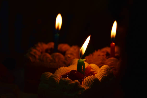 Close up shot of woman hand lightning birthday candles on the birthday cake
