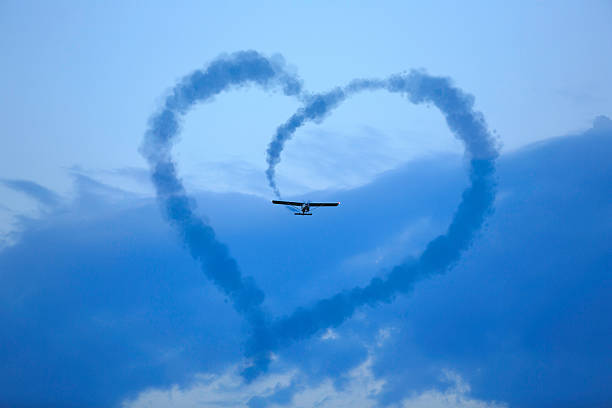 heart in the sky airplane makes a heart in the cloudy sky words in the sky stock pictures, royalty-free photos & images
