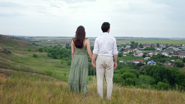Guy and lady hold hands watching life of nature and city