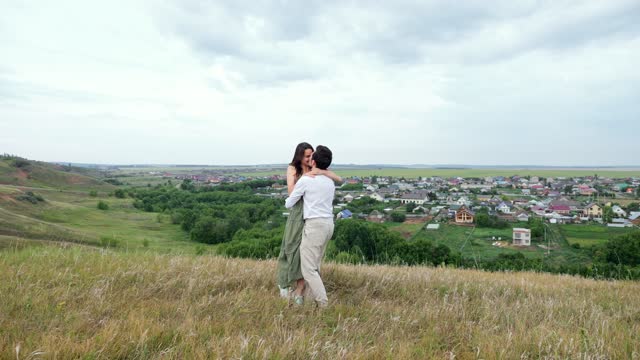 Joyful couple runs to meet each other overlooking village