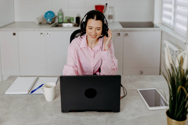 istock Young woman efficiently handles calls from her home office 1617158139