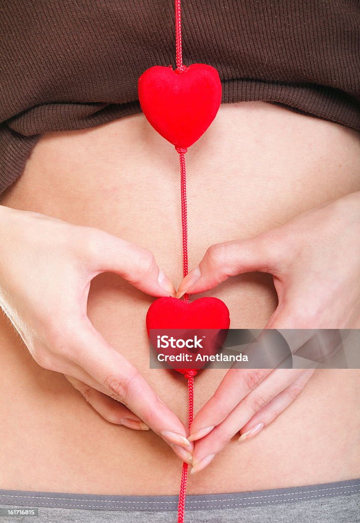 Sexy giovane donna con le mani del ventre rosso a forma di cuore - Foto stock royalty-free di Abbigliamento intimo