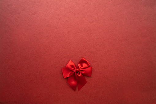Red bow on red background.