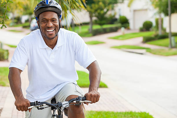 african american man riding bicicleta - polo shirt african ethnicity men african descent fotografías e imágenes de stock