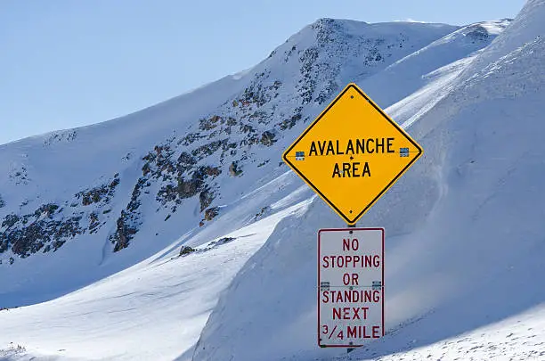 Avalanche Area Sign.  Road sign on high mountain pass.  Yellow colorful sign in english.  Loveland Pass, Colorado USA.  Captured as a 14-bit Raw file. Edited in ProPhoto RGB color space.
