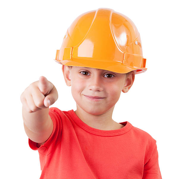 Little girl in the construction helmet points hand forward