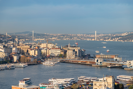 Istanbul, Turkey - April 14, 2023: A picture of the Galata Bridge on the foreground and the Bosphorus Bridge on the background.