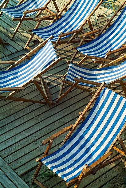 istock Row of empty blue and white striped beach chairs 161721668