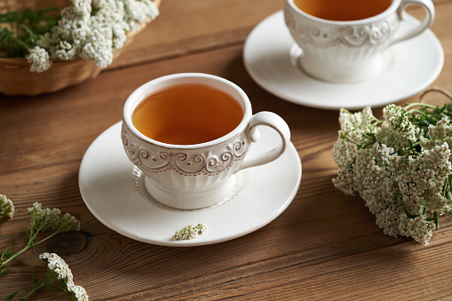 Yarrow tea with fresh Achillea millefolium flowers on a table