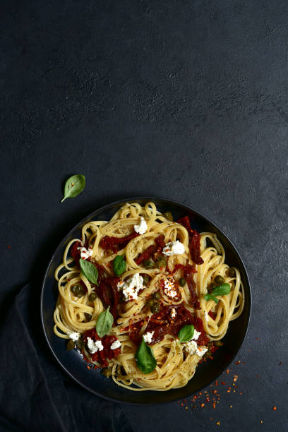 istock Pasta bavette with dried tomatoes, kapers and ricotta. Top view with copy space. 1617230485